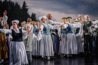Valmiera, Letonya - 7 Haziran 2025 - Geleneksel Letonya kostümlü halk dansçıları GAUJA 80 kutlamaları sırasında sahnede senkronize bir şekilde gösteri yaptılar..