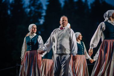 Valmiera, Letonya - 7 Haziran 2025 - Gauja dans gruplarının halk dansları, geleneksel kostümler ve Letonya kültürünün doğadaki 80. yıldönümü. GAUJA 80