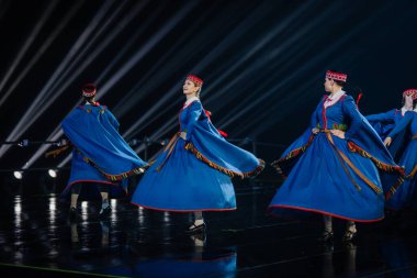 Valmiera, Letonya - 7 Haziran 2025 - GAUJA 80 'deki geleneksel Letonya halk dansları kolajı, renkli kostümlü dansçıları gece aydınlatmalı bir sahnede sergiliyorlar..