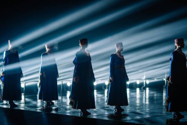 Valmiera, Letonya - 7 Haziran 2025 - GAUJA 80 'deki geleneksel Letonya halk dansları kolajı, renkli kostümlü dansçıları gece aydınlatmalı bir sahnede sergiliyorlar..