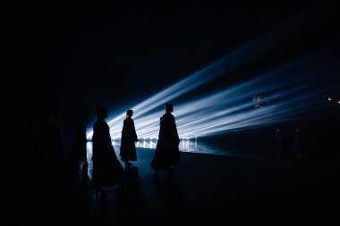 Valmiera, Letonya - 7 Haziran 2025 - GAUJA 80 'deki geleneksel Letonya halk dansları kolajı, renkli kostümlü dansçıları gece aydınlatmalı bir sahnede sergiliyorlar..