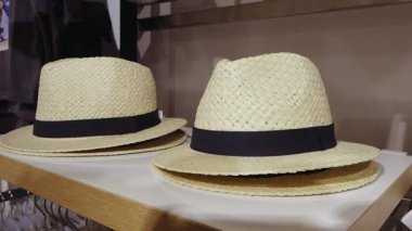 Valmiera, Letonya - 15 Haziran 2025 - Bir giyim mağazasının rafında siyah bantlı iki saman Panama şapkası, yaz modası veya plaj kıyafeti tarzı için ideal.