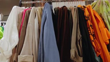 Valmiera, Letonya - 15 Haziran 2025 - Bir giyim mağazasında askıda asılı çeşitli renkli kapüşon ve ceketler,.