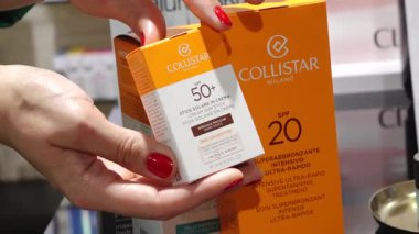 Valmiera, Letonya - 15 Haziran 2025 - Bir kozmetik mağazasında Collistar SPF 50 + güneş koruma çubuğunu inceleyen bir kadının yakın çekimi.