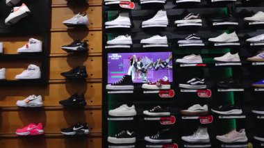 Valmiera, Letonya - 8 Temmuz 2025 Nike, Converse, Vans, Skechers ve Adidas gibi çeşitli markalı spor ayakkabıları bir perakende ayakkabı mağazasında satışa sunuldu..