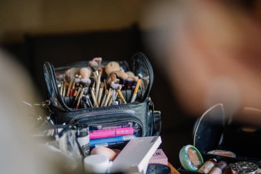 Cesis, Letonya - 17 Temmuz 2025 - Çeşitli fırçalar, kozmetik ürünleri ve aletlerle dolu profesyonel bir makyaj seti, düzgünce düzenlenmiş ve güzellik uygulaması veya tasarımı için hazır