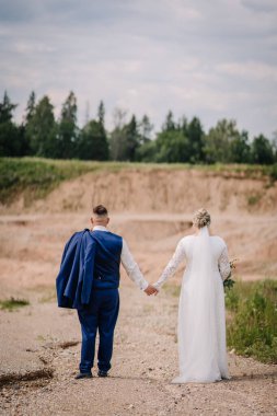 Gelin ve damat kırsal ve doğal bir ortamda çakıllı bir yolda el ele yürürler. Arkalarından yakalanan gelinlerin peçeleri birlikte ilerlerken akar.