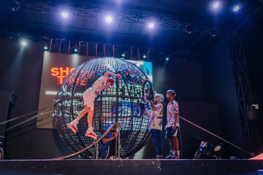 Kemer, Turkey, September 22, 2025 - A rollerblader performs a daring stunt mid-air while others prepare with a BMX in front of the illuminated globe at the Extreme Globe Show.