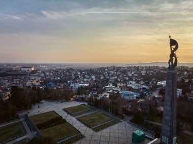 Bratislava, Slovakya 'da gün batımında Slavin anıtı ve askeri mezarlığın insansız hava aracı görüntüsü