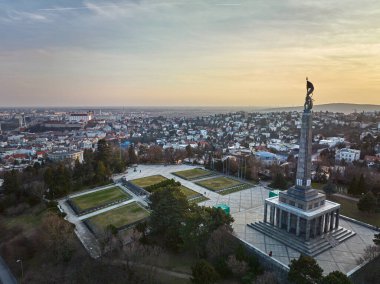 Bratislava, Slovakya 'da gün batımında Slavin anıtı ve askeri mezarlığın insansız hava aracı görüntüsü