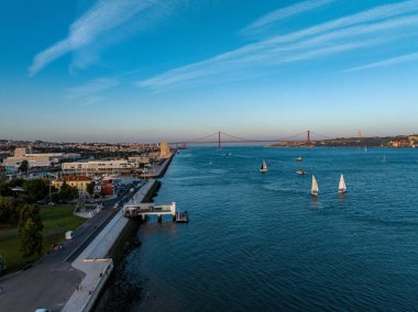 Portekiz, Lizbon 'da günbatımında Ponte 25 de abril köprüsü ve Tagus nehrinin manzarası