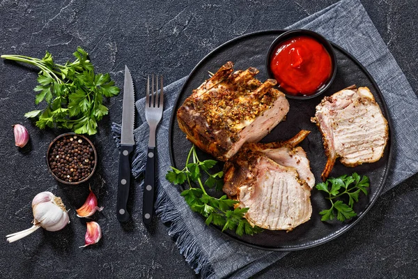 Standing Pork Rib Roast Cut Chops Black Plate Tomato Sauce — Stock Photo, Image