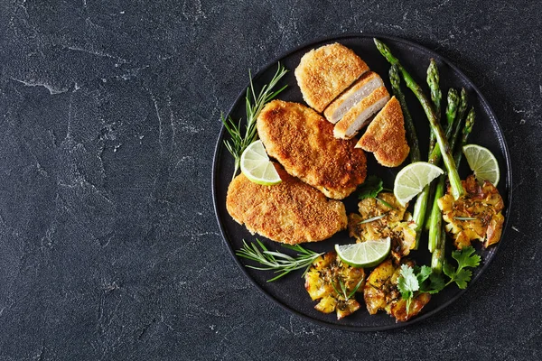 Fried Breaded Chicken Breasts Roast Asparagus Smashed Potatoes Lime Black — Stock Photo, Image