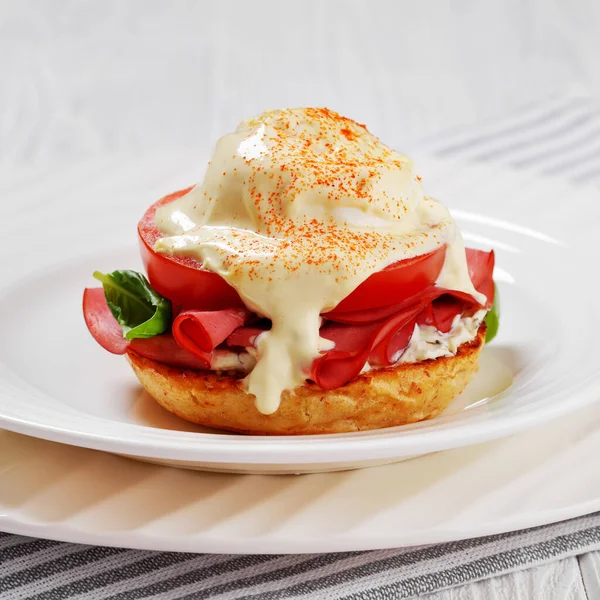 Närbild Ägg Benedict Med Engelsk Muffins Mjukost Skinka Tomat Basilikablad — Stockfoto