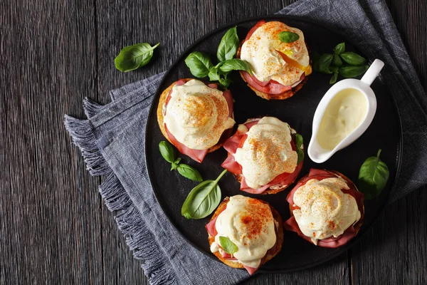 Eggs Benedict English Muffin Soft Cheese Ham Tomato Basil Leaves — Stock Photo, Image