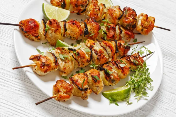 Close Chicken Skewers Thyme Lime Wedges White Plate White Wooden — Stock Photo, Image