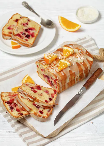 Plasterki Pomarańczowego Chleba Żurawinowego Pomarańczową Glazurą Białej Drewnianej Desce Nożem — Zdjęcie stockowe