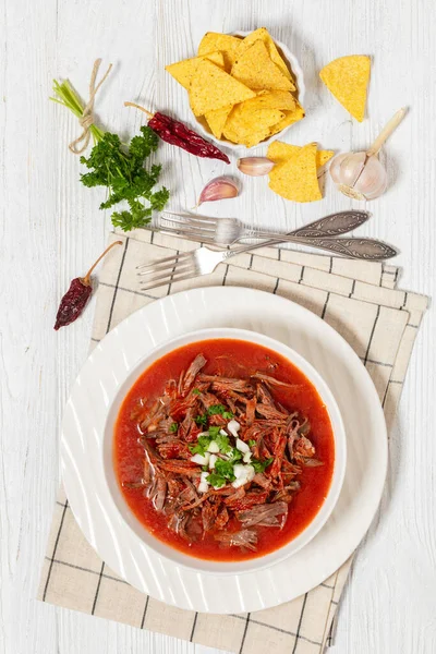 生洋葱热红辣椒酱汁中的墨西哥牛肉炖肉 白碗中的切碎香菜 配以玉米片和配料 从上往下垂直观看 — 图库照片