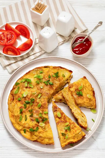 传统的西班牙土豆煎蛋卷 玉米饼片在白色木制桌子上的盘上 西红柿和番茄酱 从上方垂直观看 — 图库照片