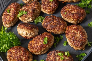 frikadeller, danish meatballs of minced pork on grey plate on black wooden table, vertical view from above, close-up, dutch angle view clipart