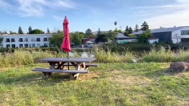 Picknicktafel Met Een Rode Parasol Voor Een Meer — Stockvideo