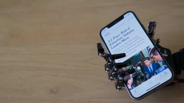 Робот Держит Телефон Показывающий Новости Связанные Опасностями Искусственного Интеллекта — стоковое видео