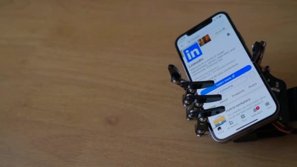 Robot Holding Phone Linkedin App Screen — Stock Video