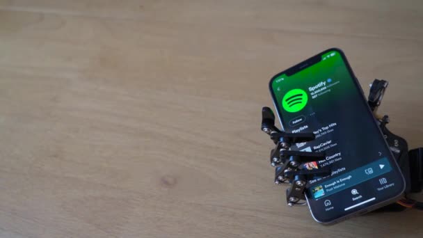 Роботизированная Рука Держит Телефон Приложением Spotify Экране — стоковое видео