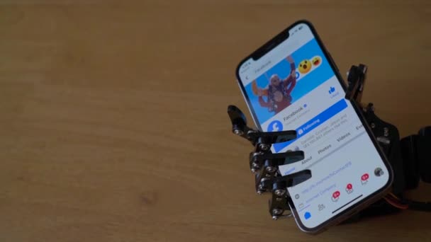 Robotic Hand Holding Iphone Med Facebook Nettsted Skjermen – stockvideo