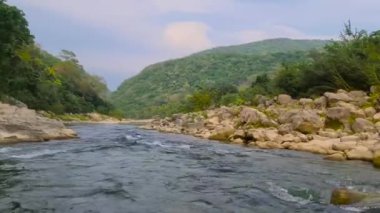 Kayalarla dolu akıntılarda yol alan kişi