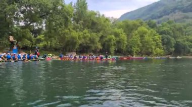 İnsanlar tekne yarışını kazanmak için hızla kürek çekiyor.