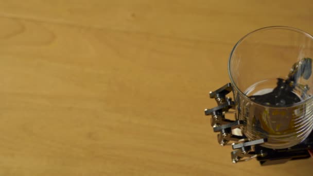 机器人手拿着一只空玻璃杯 照相机慢悠悠地扫视着它 — 图库视频影像