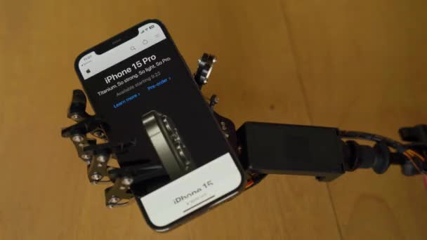 Tangan Robotic Memegang Telepon Dengan Situs Web Apple Dan Iphone — Stok Video