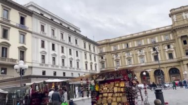 Floransa 'da bir atlıkarınca, sokak müzisyenleri ve Piazza della' nın tarihi kemeriyle hareketli bir meydan..