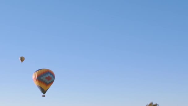 2つのカラフルな熱気球は 自由と冒険の感覚を提供する広大な澄んだ青空に上昇します — ストック動画