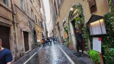 Yağmurlu bir günde bir hatıra kulübesi, Roma şehrinin arka planına ve sessiz renklerine karşı çıkıyor.