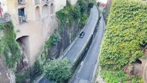 緑豊かな緑と古代の壁の間に位置する孤独な車は 建築遺産と自然の美しさが豊富な歴史的な町で静かな瞬間をカプセル化し 隠された道路を移動します — ストック動画