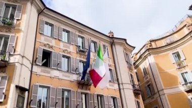  Roma 'da tarihi bir binada asılı duran İtalyan bayrakları, ulusal gurur ve şehrin mimari güzelliğini yansıtıyor..