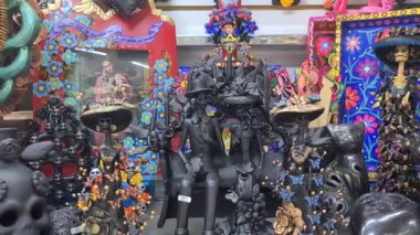 Renkli Ölüler Günü heykelcikleri sergileniyor. Karmaşık tasarımlar ve canlı renkler sergileniyor. Rakamlar geleneksel Meksika kültürünü ve sanatını temsil ediyor.