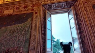 Vatikan Müzesi 'nin penceresinden çok güzel çerçevelenmiş bir manzara. Detaylı duvar süslemeleri ve dışarıdaki yeşilliği gösteren bir manzara. Sahne sanatın ve doğanın karışımını yakalar..