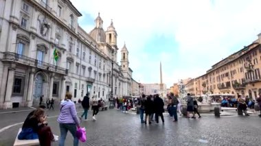 Roma 'daki Piazza Navona' yı keşfeden turistler, tarihi mimariyle çevrili ve hareketli bir meydan. Parlak gün, bu ünlü Roma meydanının canlı atmosferini vurguluyor..