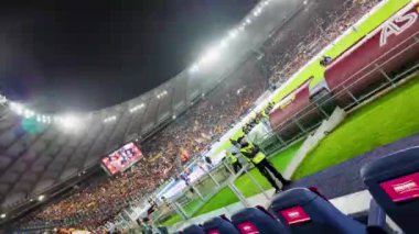 Geceleyin yoğun bir maç sırasında futbol stadyumunu doldurdu. Kalabalık hareketli ve oyun parlak stadyum ışıkları altında sergilenirken atmosfer de heyecan verici..