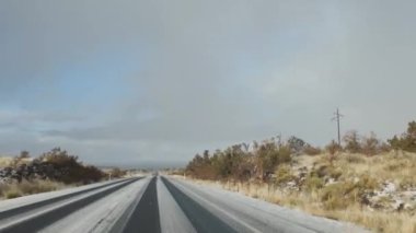 AZ-89A karayolunun bir uzantısı. Karla kaplanmış, yol ufka doğru uzanıyor. Kış mevsiminde Arizona yollarının sessiz güzelliklerini yakalar..
