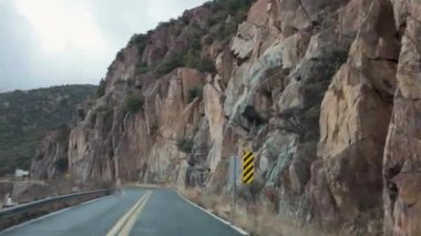 Otoyol AZ-89A 'da dar, virajlı bir yol. Dik kayalıklarla çevrili. Sahne engebeli araziyi ve Arizona 'dan geçen bu manzaralı yolun doğal güzelliğini yakalıyor..