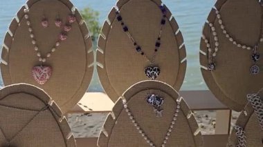 Chapala Gölü 'ne bakan açık bir mücevher sergisinde el yapımı kolyeler ve küpeler sergileniyor. Doğal göl arkaplanı sanatsal yaratıkların cazibesini arttırır..