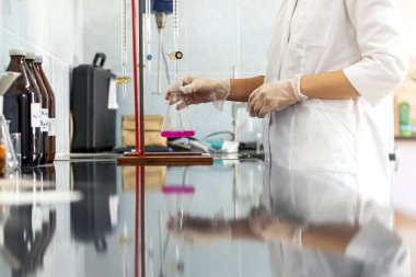 Chemistry expert is working with solutions and test tubes on the workbench in a chemistry laboratory. is a facility that provides controlled conditions in which scientific or technological research.