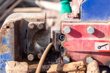 Construction worker is cutting to rebar in the site. Rebar (short for reinforcing bar), known when massed as reinforcing steel or reinforcement steel is a steel bar or mesh of steel wires.