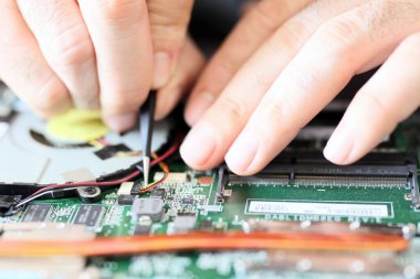 Expert is repairing to inner of laptop with screwdriver. The design restrictions on power, size, and cooling of laptops limit the maximum performance of laptop parts compared.