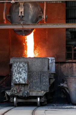 Metalurjik bir fabrikada demir ve çelik eritme işlemi. Bakırın kızgın kevaşesi büyük eritme kabına dökülüyor..
