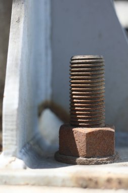 Yapı çeliğinin kenarına paslı çelik bir demir cıvata. Çapa cıvataları yapısal ve yapısal olmayan elementleri betona bağlamak için kullanılır.